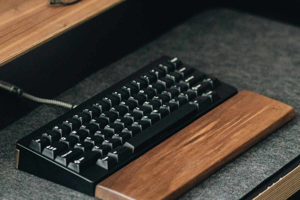 木のリストレスト付きの黒いキーボード